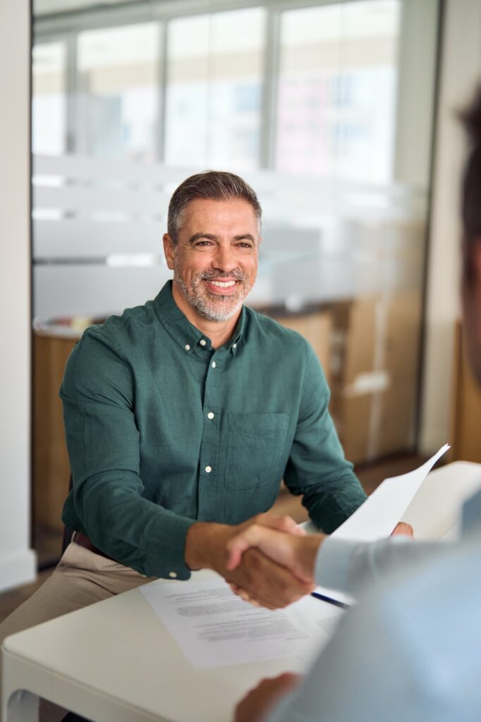 Recruiting handshake of hr manager and new worker at job interview.